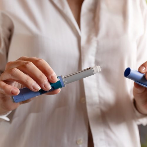 Uma senhora com uma caneta injetável para o tratamento da obesidade
