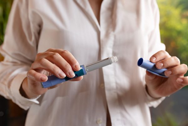 Uma senhora com uma caneta injetável para o tratamento da obesidade